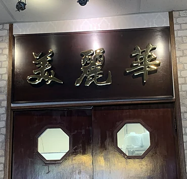 Wooden kitchen doors under a gold Chinese-character sign at Miriwa Restaurant