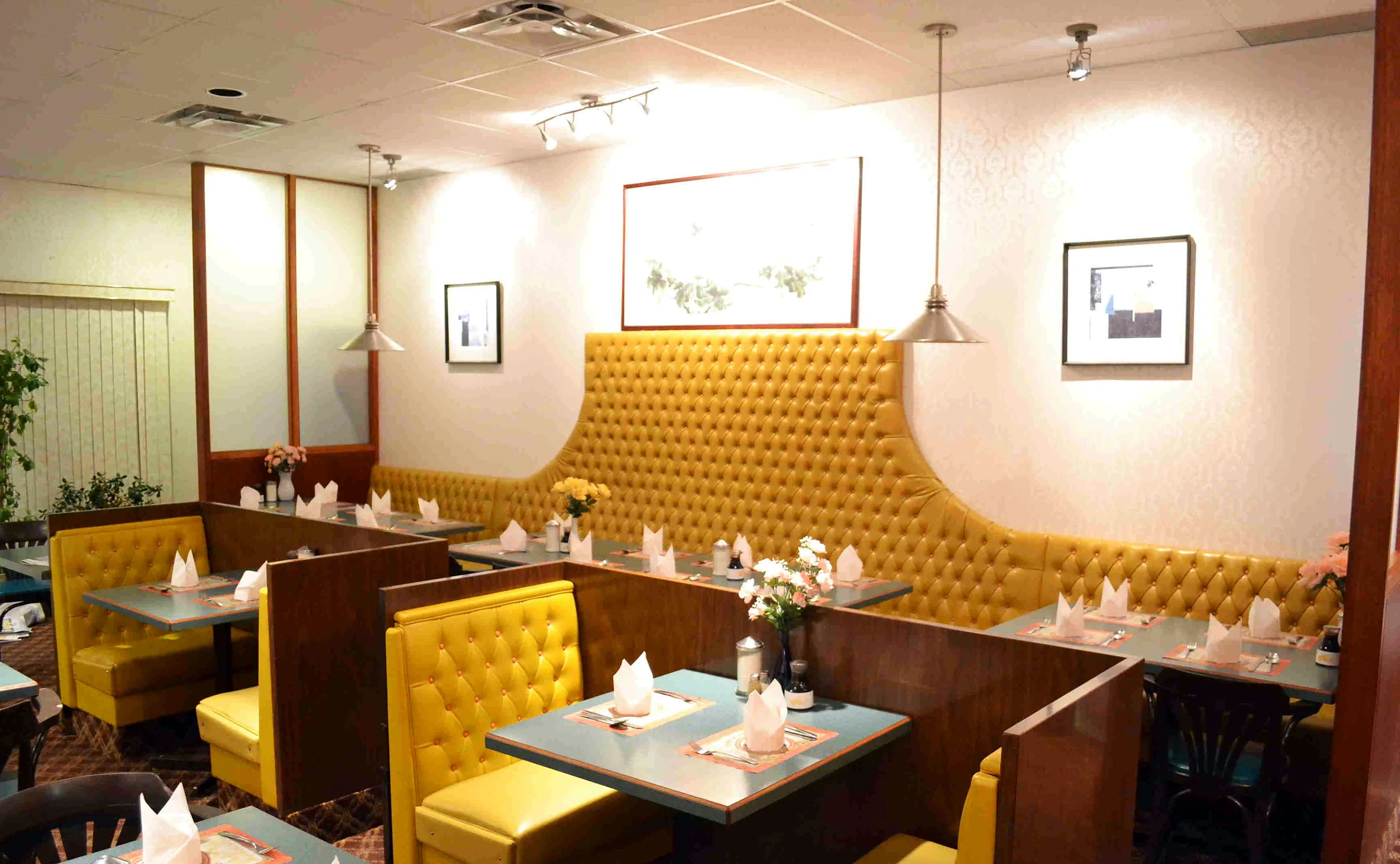 Miriwa Restaurant dining room with yellow tufted booths and set tables