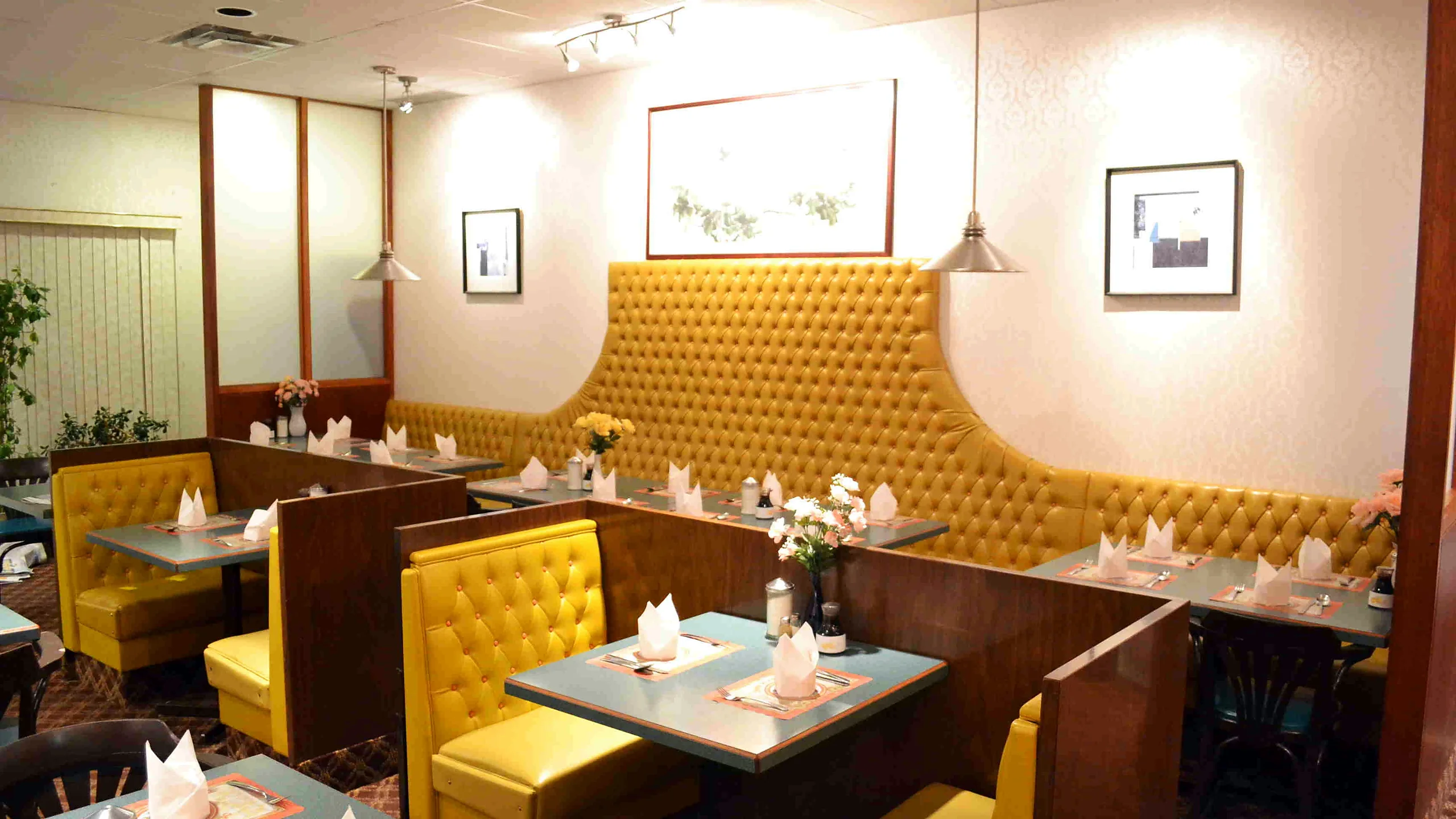 Miriwa Restaurant dining room with yellow tufted booths and set tables